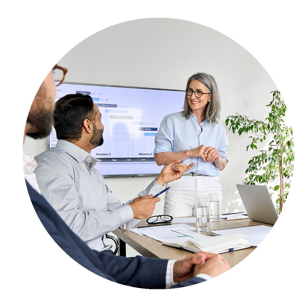 Circular image of female office worker speaking with colleagues