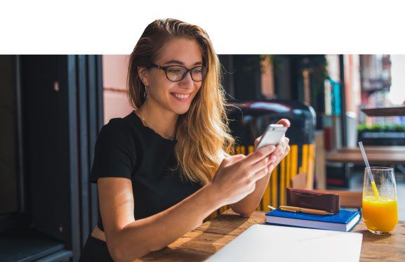 Female office worker looking down at her phone smiling